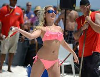 girl throwing a fish at the Flora Bama Mullet Toss in Gulf Shores