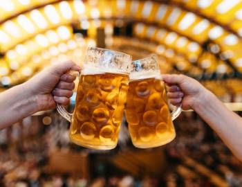 people toasting with beer steins at oktoberfest celebration