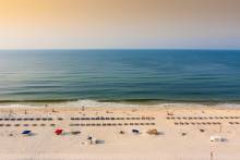 view of Gulf of Mexico and beach chairs on sand at sunrise