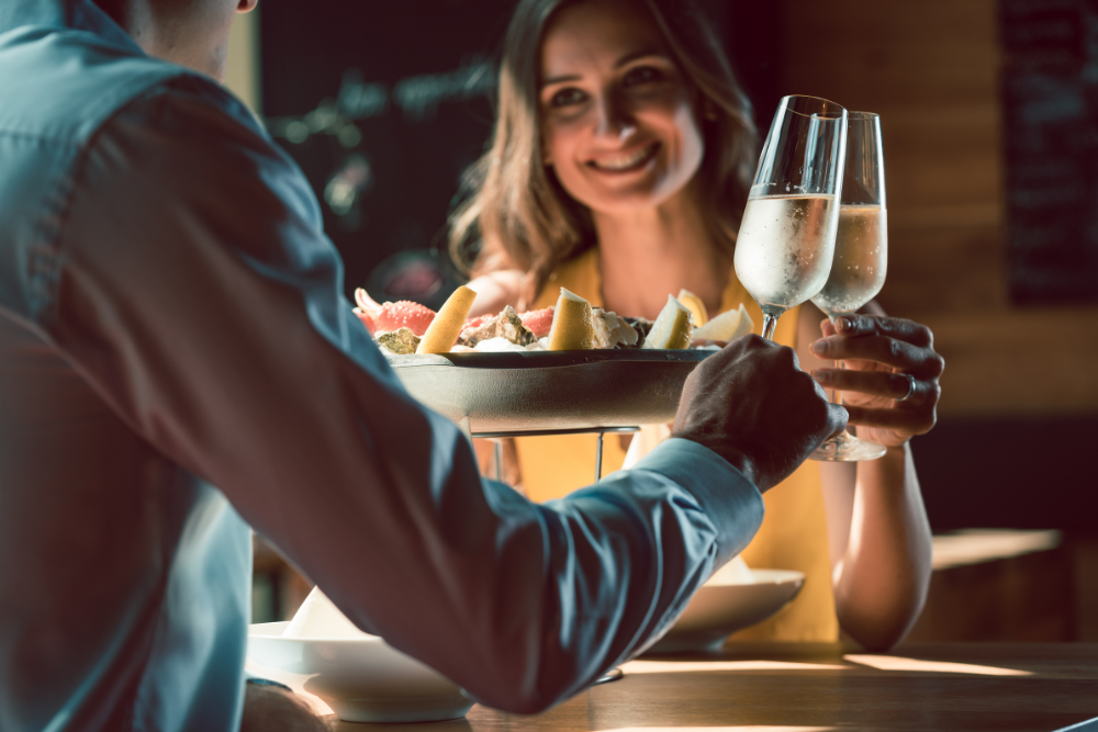 couple eating dinner at restaurant and cheers with wine